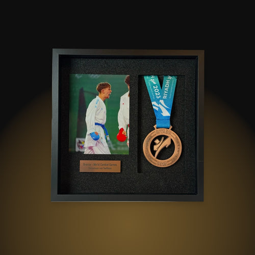 The Podium Collection frame photographed in the studio, with a photo, a bronze medal and a nameplate