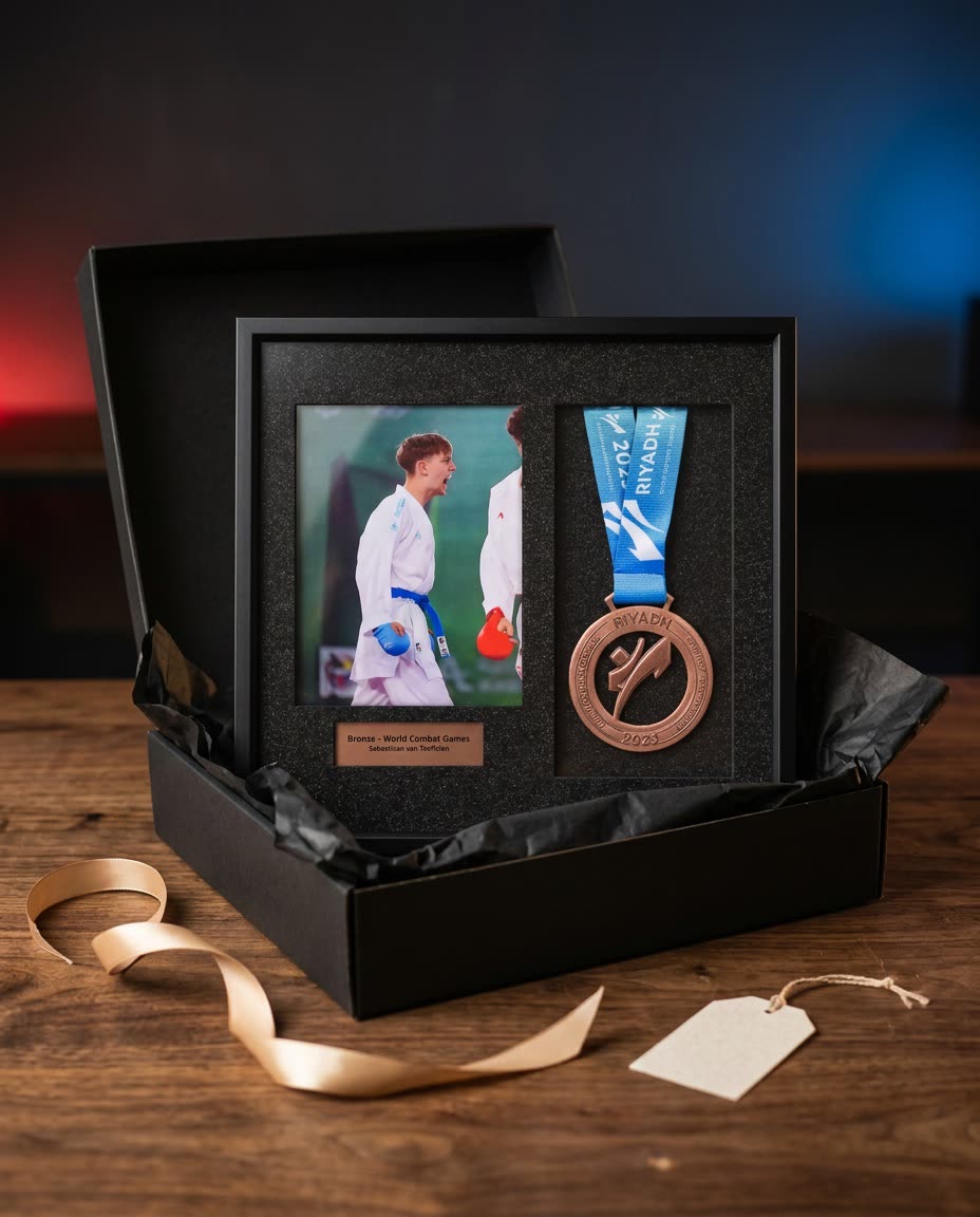 The frame in an open black gift box with tissue paper, a gold ribbon and a gift tag