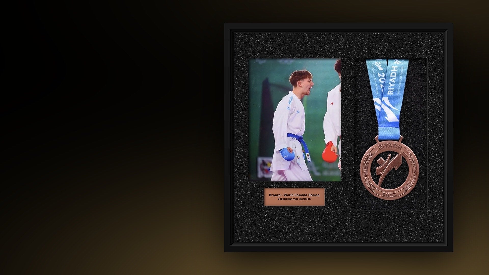 Black medal frame with an athlete's photo, a bronze medal and an engraved nameplate